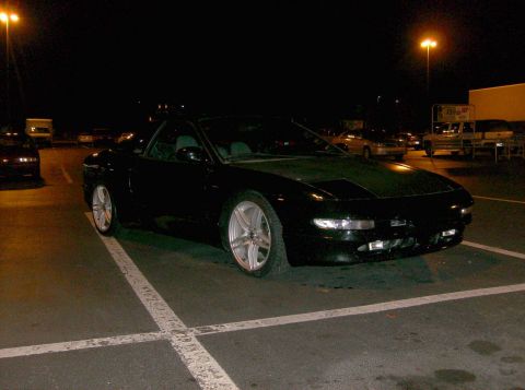1995 Ford Probe - A black 1995 Ford Probe GT is parked in a lot at night, with aftermarket wheels visible.