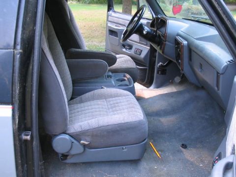 1989 Ford Bronco - The interior of a 1989 Ford Bronco, cloth seats, a center console, and dashboard details.