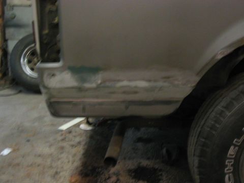 1989 Ford Bronco - This vehicle's rear quarter panel is being prepped for paint, with visible body filler and primer.