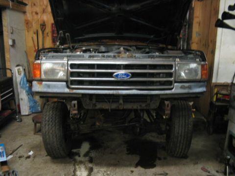 1989 Ford Bronco - Front view of a 1989 Ford Bronco in a garage, hood up.