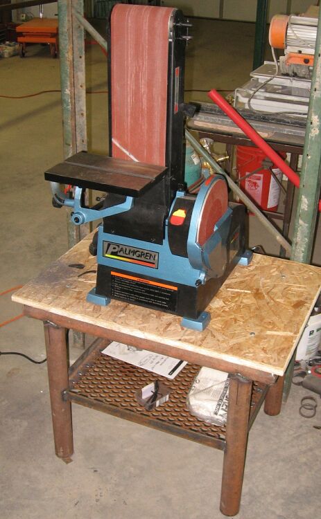 1990 Ford Bronco - A blue and black belt and disc sander sits on a rough wooden table in a workshop setting.