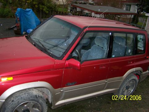 1988 Suzuki Samurai - This red Suzuki Sidekick is shown from the 3/4 front view. The registry label may be incorrect.