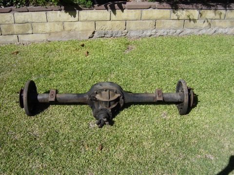 1983 Ferrari Enzo - A rear axle assembly is displayed on a grassy lawn with a brick wall behind it.