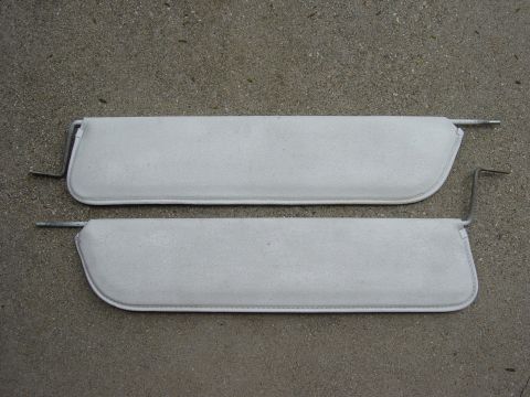 1983 Ferrari Enzo - Two light gray sun visors are shown laid out on a concrete surface, each with a metal mounting arm attached.