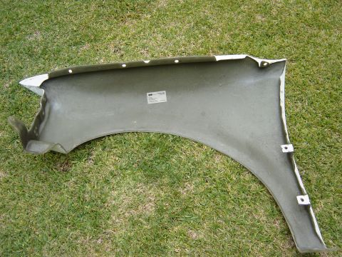 1983 Ferrari Enzo - A close-up view of the interior of a car fender, showing mounting points and a label.