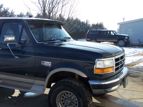 1995 Ford C-350 (Centurion Conversions) - A dark blue Ford F-Series truck is parked in a driveway with snow on the ground. Another vehicle is visible in the background.