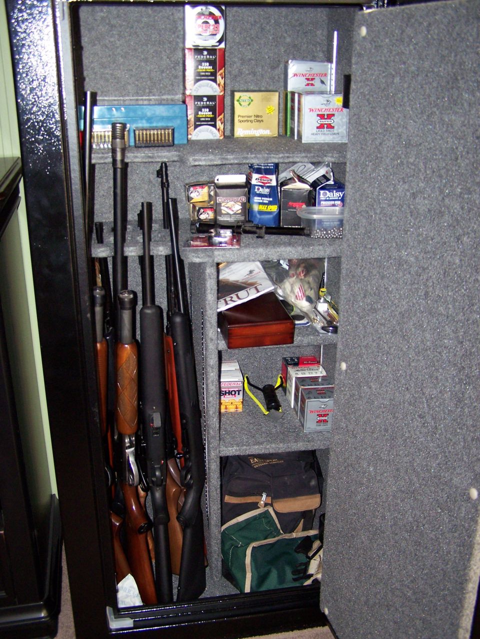 Gun safe interior with rifles and boxes of ammunition on shelves