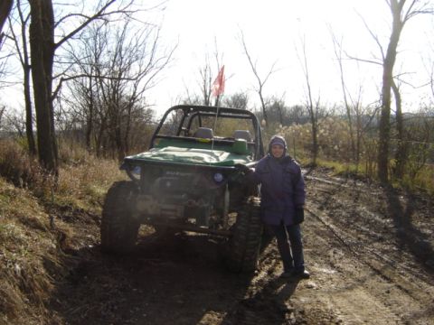 1992 Ford Bronco - A person poses with a modified Suzuki Samurai on a dirt path surrounded by trees.