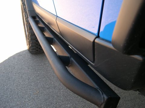 2007 Toyota FJ Cruiser - Close-up of the side of a blue 2007 Toyota FJ Cruiser, highlighting its rock sliders and fender flares.
