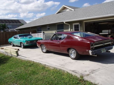 1969 Ford Torino - A maroon 1969 Ford Torino is parked in front of a teal 1969 Ford Torino in a suburban driveway.