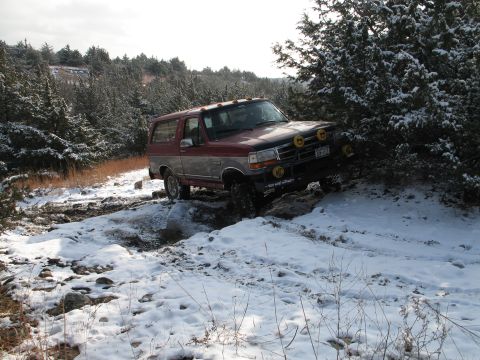 1995 Ford Bronco - This 1995 Ford Bronco navigates a challenging snowy path through a wooded area.