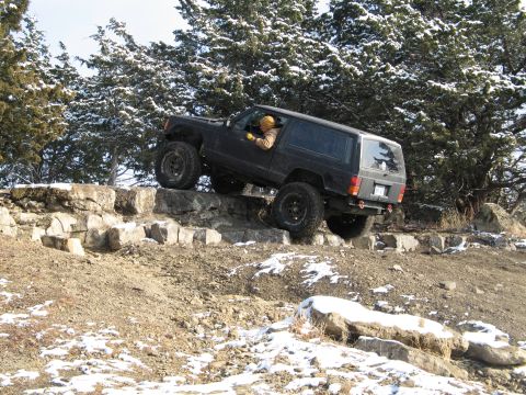 1995 Ford Bronco - A modified Jeep Cherokee XJ navigates a rocky obstacle course during winter conditions.