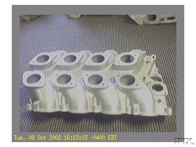 1965 Shelby Cobra - An intake manifold with multiple ports is shown against a carpeted background.