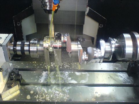 1964 Ford 427 - A crankshaft is precisely machined on a CNC mill, with coolant actively lubricating the process.