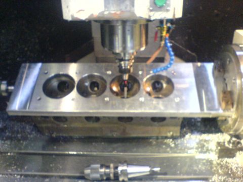 1964 Ford 427 - A close-up view shows an engine cylinder head being precisely machined on a CNC milling machine.