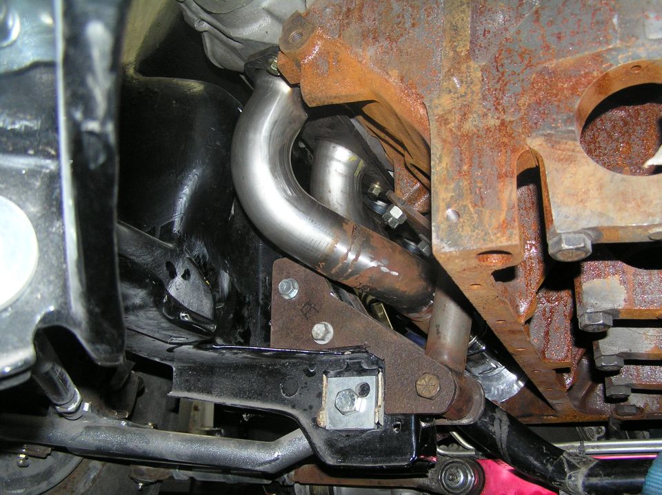 close-up of exhaust pipes connected to a rusty engine block