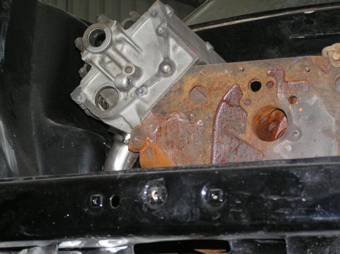 1964 Ford 427 - Close-up view of an engine block and a heavily rusted metal component within a vehicle.