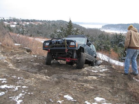 1995 Ford Bronco - Jeep Cherokee XJ navigating a challenging off-road trail in winter conditions.