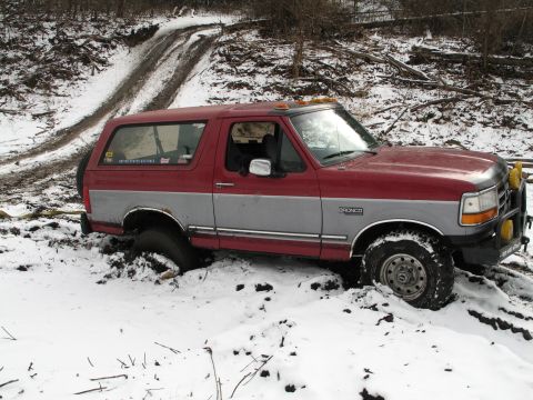 1995 Ford Bronco - A 1995 Ford Bronco is stuck in the mud and snow on an off-road trail.