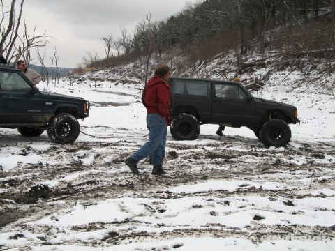 1995 Ford Bronco - Two modified Jeep Cherokee XJs navigate a challenging snowy and muddy terrain.