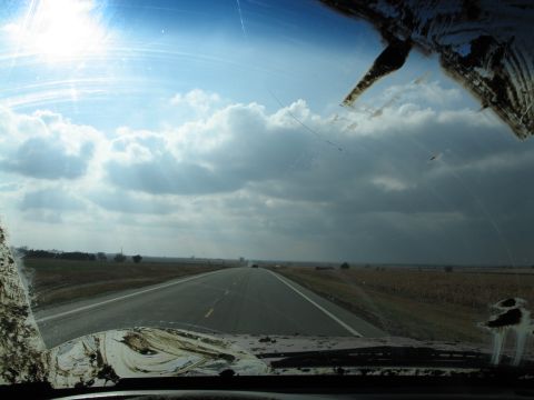1995 Ford Bronco - View from inside a vehicle shows a highway ahead with a dirty windshield and dashboard in the foreground.