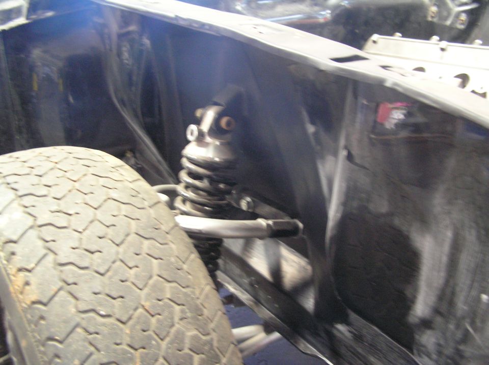 Close-up of a car's front suspension shock absorber and tire