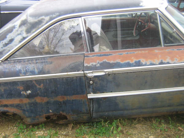 1963 Ford Galaxie interior showing steering wheel and dashboard, side view of rusty body panels