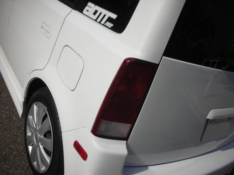 2006 Scion xB - Close-up of a white car's rear section, showing the taillight and a window sticker.
