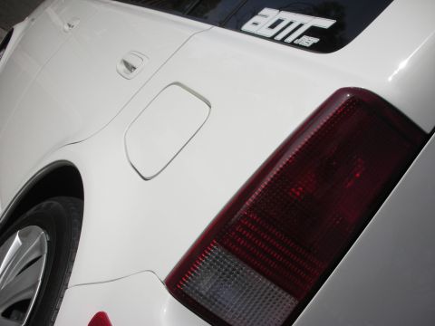 2006 Scion xB - Close-up of the rear of a white 2006 Scion xB, showing the taillight and a sticker on the window.