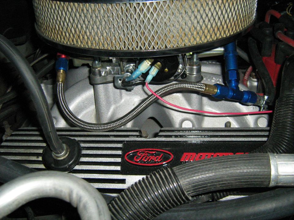 Close-up of a Ford engine with a chrome air filter housing and braided fuel lines