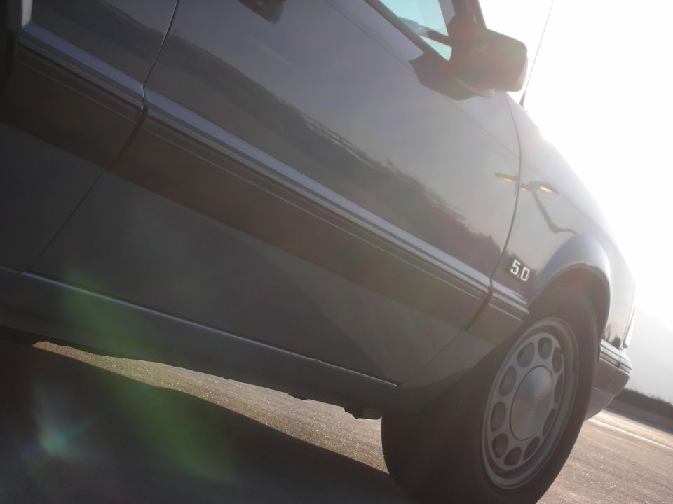 Side view of a 1990 Ford Mustang showing the 5.0 badge and wheel