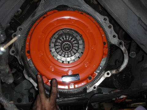 1990 Ford Mustang - Close-up view of an orange clutch assembly, showing the pressure plate and splined hub.