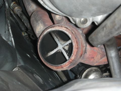 1990 Ford Mustang - Close-up of a vehicle's exhaust pipe interior, revealing internal baffles and signs of use.