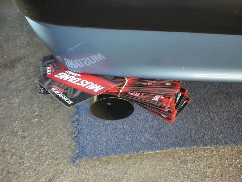 1990 Ford Mustang - A stack of Mustang promotional cards, including Boss 302, are visible under a vehicle's bumper.