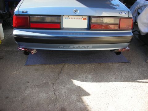 1990 Ford Mustang - Rear view of a light blue 1990 Ford Mustang, showing its bumper, taillights, and exhaust system.