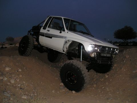 1986 Toyota Hilux - This heavily modified pickup truck is shown off-road at dusk.