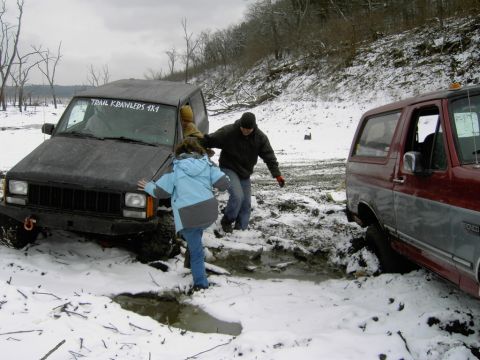 1995 Ford Bronco - A 1995 Ford Bronco is stuck in a muddy, snow-covered area, with a Jeep Cherokee also present and people attempting to navigate the free the…