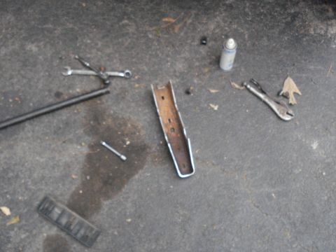 1984 Ford Bronco - Tools and car parts laid out on the ground, possibly for a repair or project.