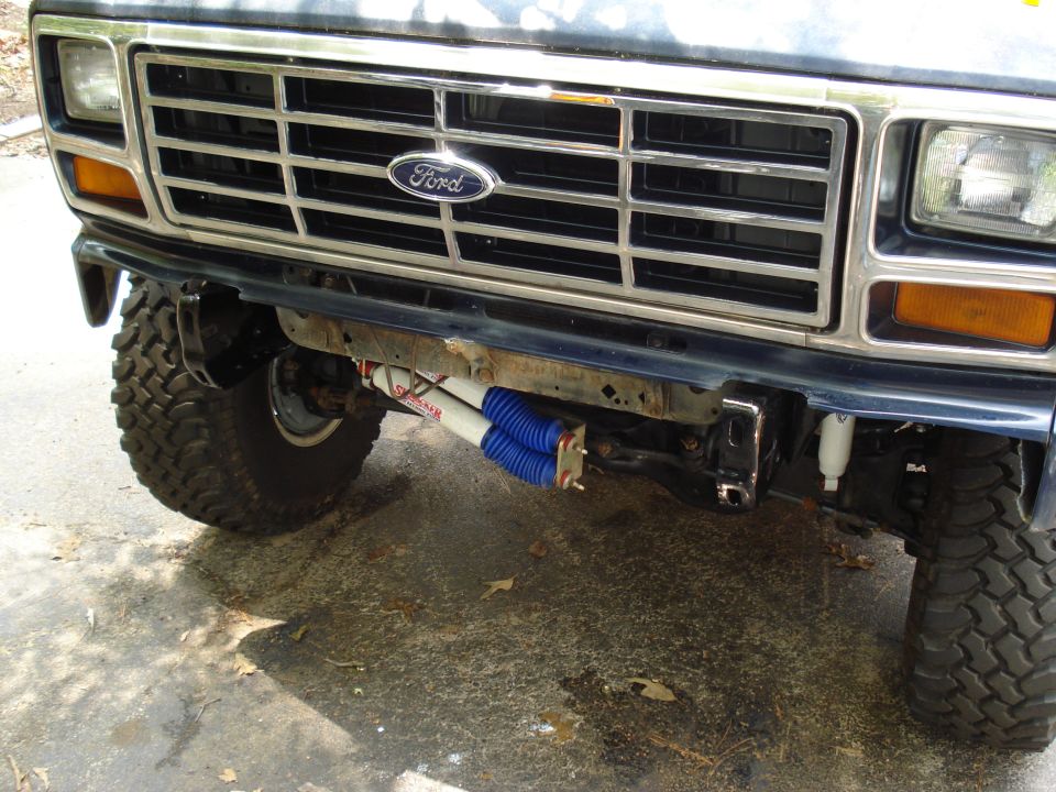 Front view of a 1984 Ford Bronco with aftermarket shocks visible below the bumper