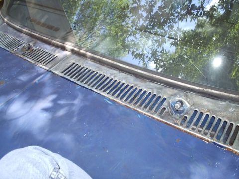 1978 Ford Bronco - Close-up of the cowl vent grille on a 1978 Ford Bronco, showing blue paint and some rust.