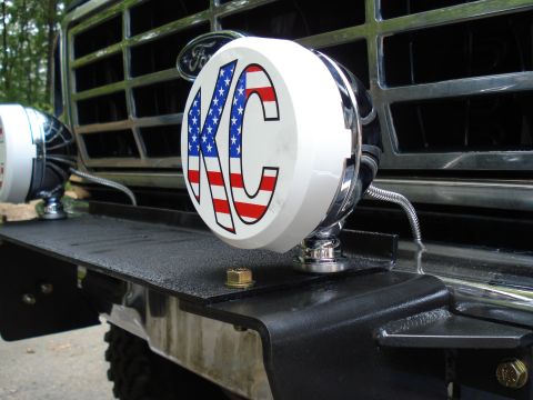 1984 Ford Bronco - Close-up of a Ford Bronco's front end, showing KC lights and a chrome grille.