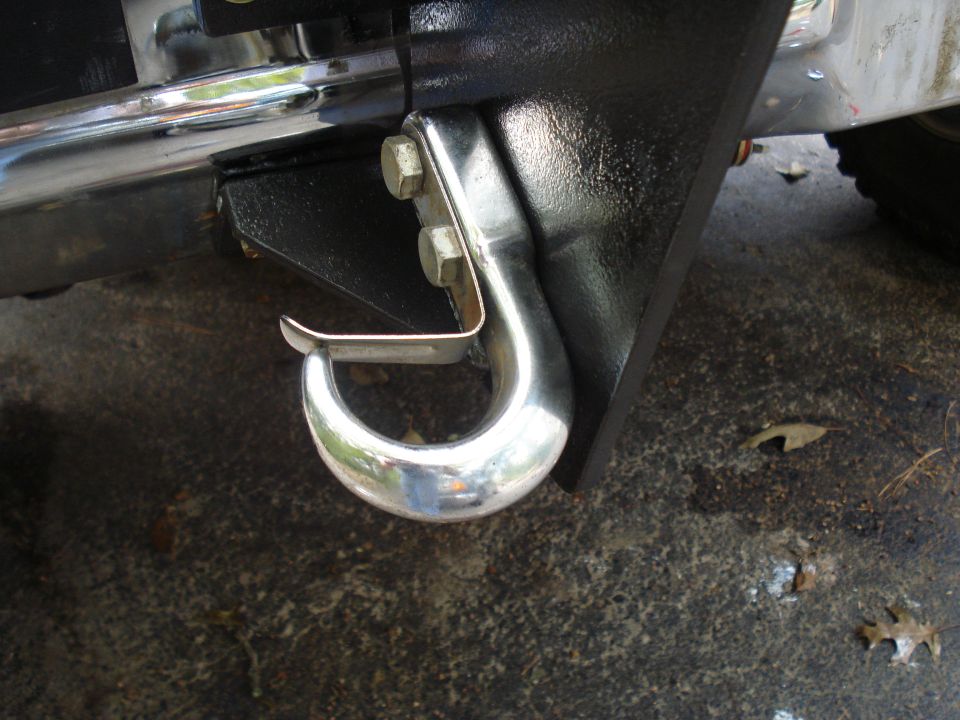 Chrome tow hook attached to black bumper bracket with two bolts