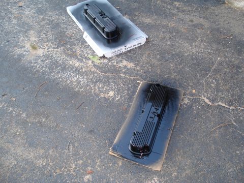 1984 Ford Bronco - Valve covers are being painted black on a concrete surface.