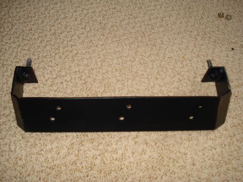 1984 Ford Bronco - A black metal bracket with mounting points is shown against a carpeted background.