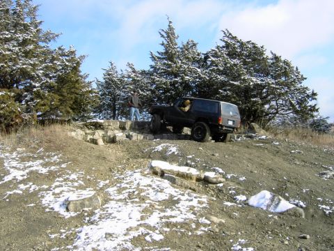 1995 Ford Bronco - Jeep Cherokee XJ navigating a challenging off-road course with snow on the ground.