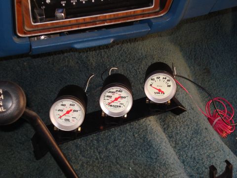 1984 Ford Bronco - Aftermarket gauges for oil pressure, water temperature, and voltage are installed in the vehicle's cabin.