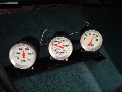 1984 Ford Bronco - Aftermarket gauges for oil pressure, water temperature, and voltage are installed in a vehicle's interior.