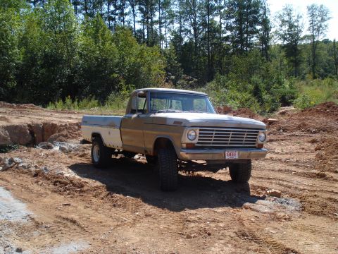 1967 Ford F-250 - This 1967 Ford F-250 pickup truck is seen in a rural, wooded area with a dirt road and construction site.
