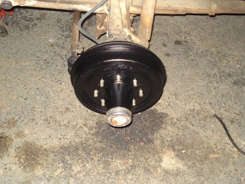1967 Ford F-250 - Close-up view of a vehicle's rear axle drum brake assembly, showing the brake drum and wheel studs.