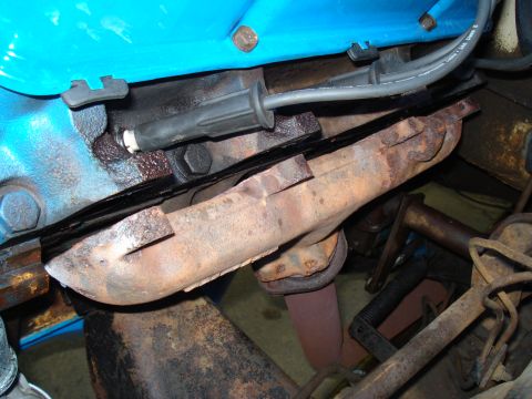 1967 Ford F-250 - Engine detail showing a spark plug wire and exhaust manifold, likely from an older vehicle.